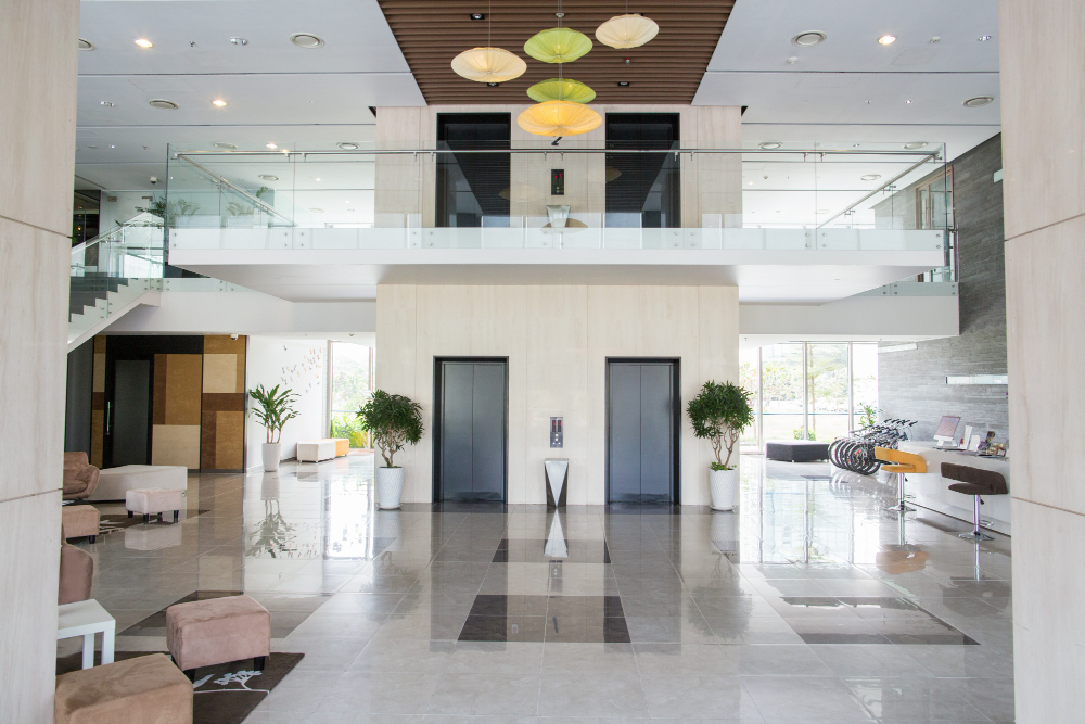 A modern commercial building lobby with glass railings and elevators, the type of property covered under Commercial Property Insurance Florida.