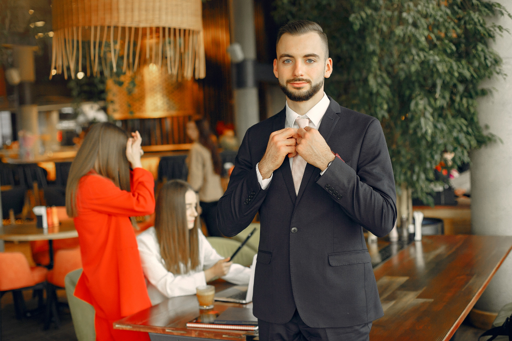 A host adjusting his tie inside a decorated venue with guests nearby, the gatherings 3A Allied Insurance covers with Special Event Liability Insurance.