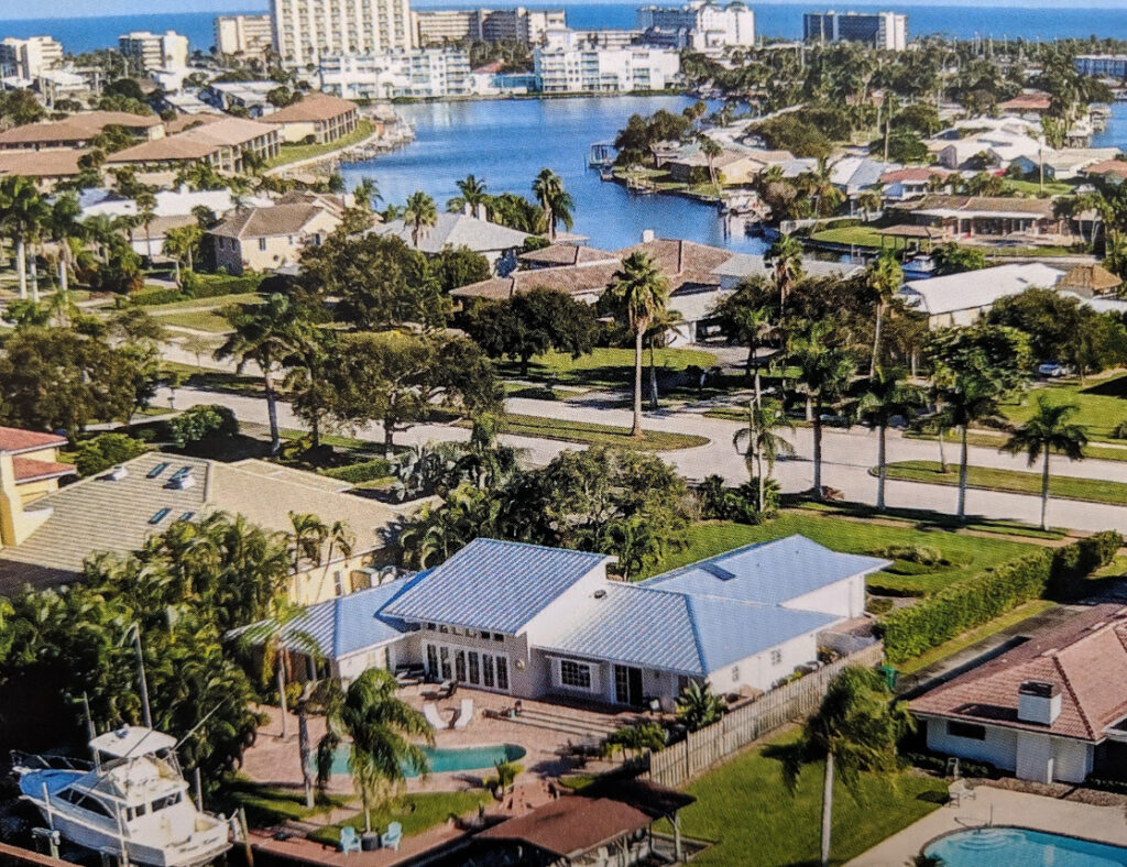 Brevard County Insurance coverage area aerial image of waterfront homes with boat docks and pools along a canal, with the coastline in the background.