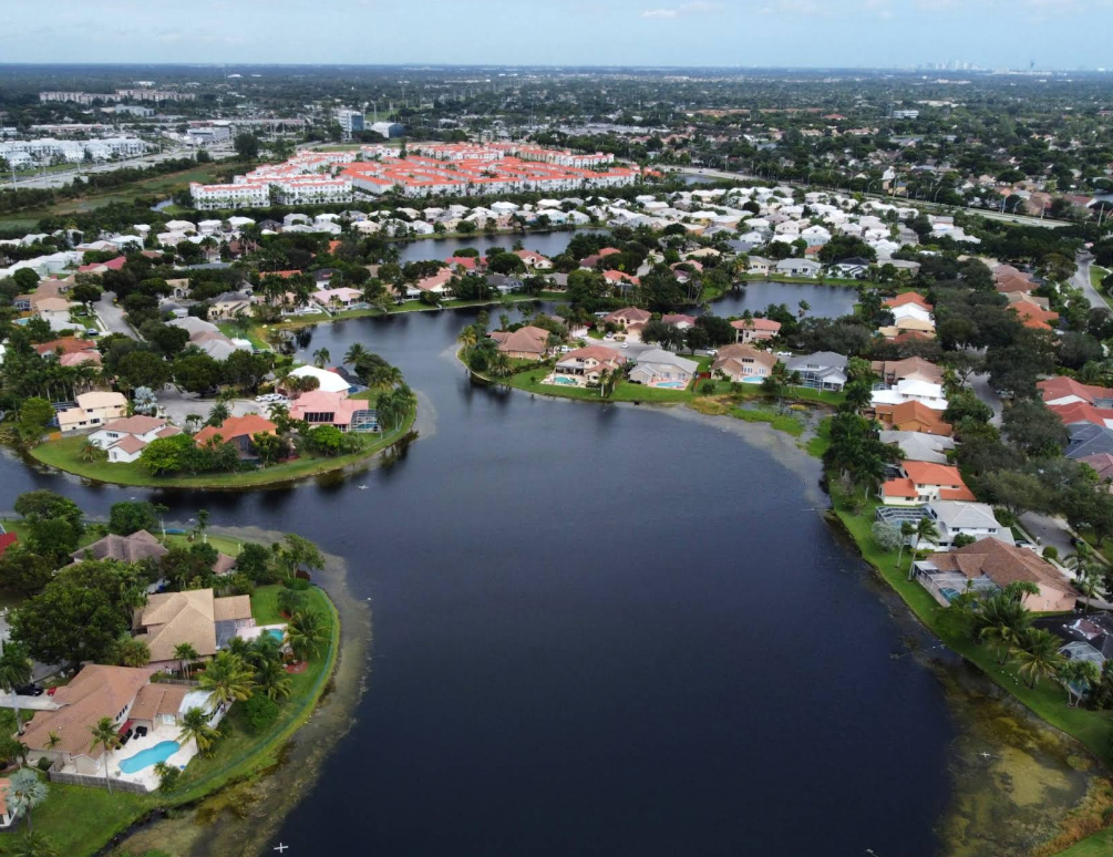 Broward County Insurance coverage area aerial image of a lakeside residential community with red-roofed homes and pools near Fort Lauderdale.