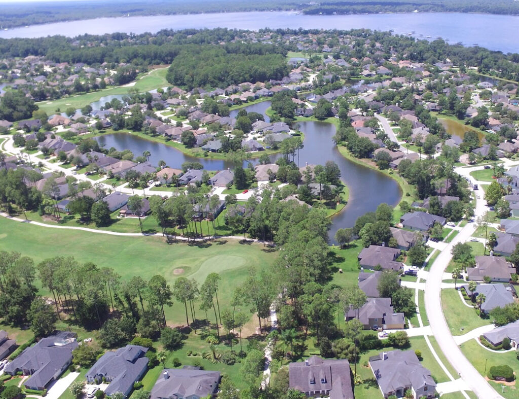 Clay County Insurance coverage area aerial image of a suburban neighborhood with lakes, a golf course, and tree-lined streets near Jacksonville.