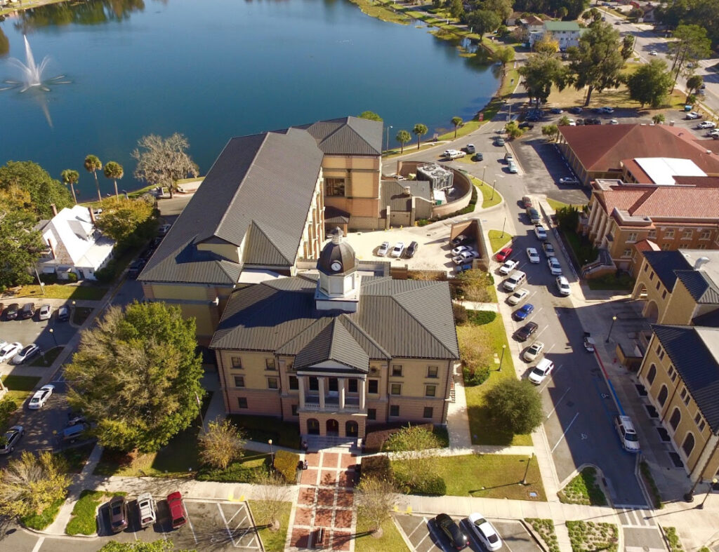 Columbia County Insurance coverage area aerial image of the historic courthouse building beside a lake with a fountain in Lake City, Florida.