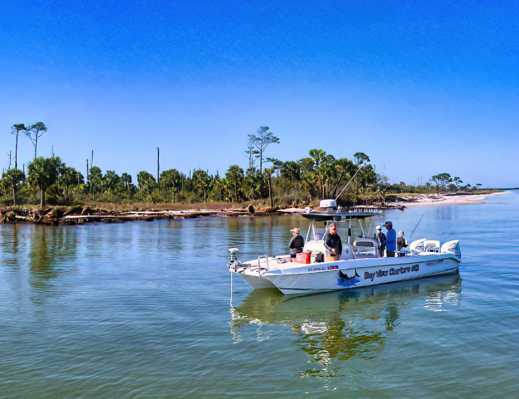 A charter fishing boat with passengers near a Franklin County shoreline, reflecting the waterfront fishing exposure Franklin County Insurance covers.
