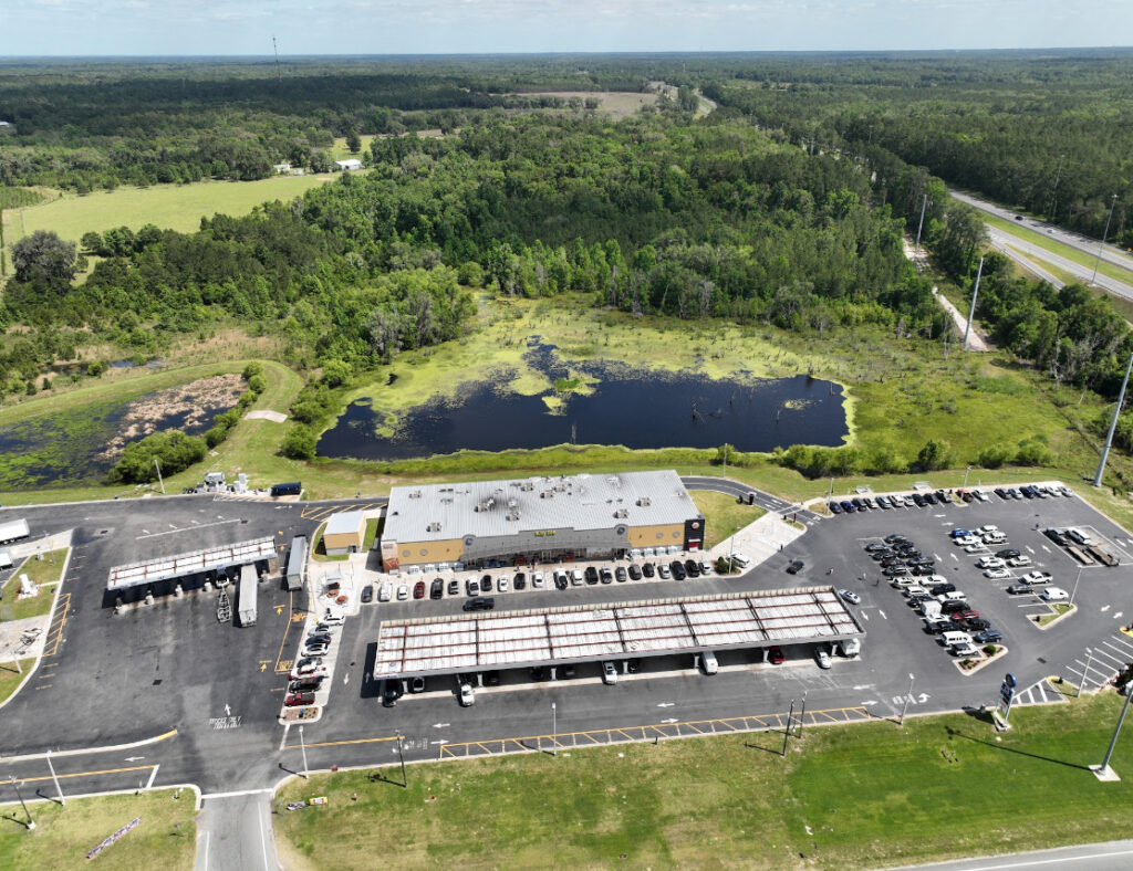 A rural travel plaza bordered by farmland and forest in Suwannee County, the agricultural landscape 3A Allied Insurance covers with Suwannee County Insurance.
