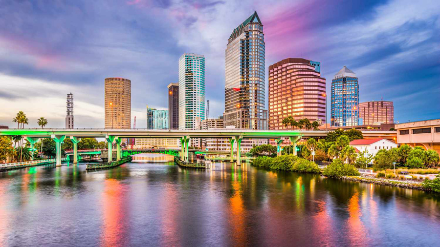 Downtown Tampa's skyline glows at twilight and reflects across the river, representing the Tampa Bay Insurance coverage 3A Allied provides throughout the area.